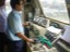 Loco pilot with one hand on master controller, another on Train Brake handle with Loco Inspector